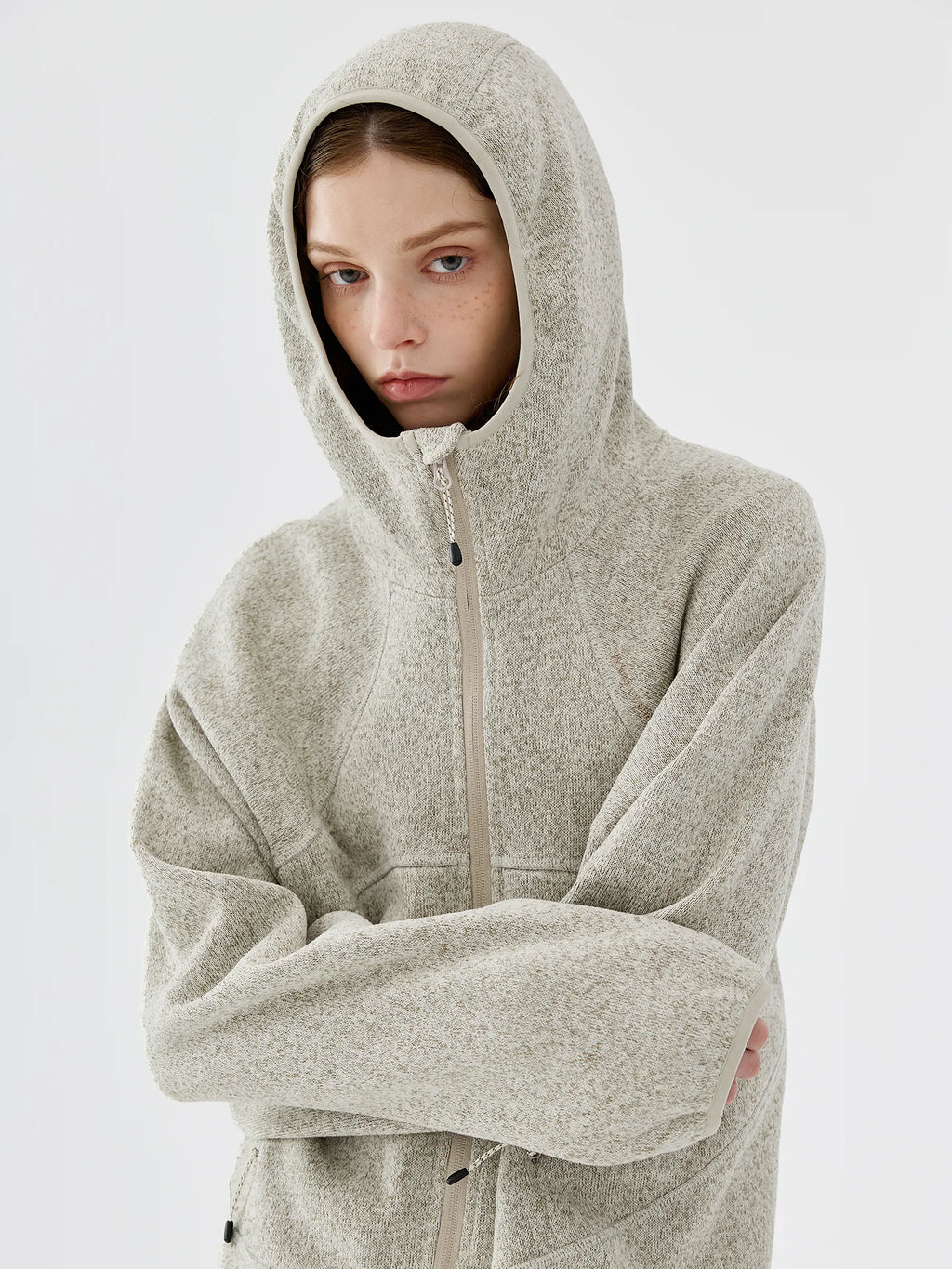 Close-up of model wearing the hood of a light grey melange knit fleece jacket