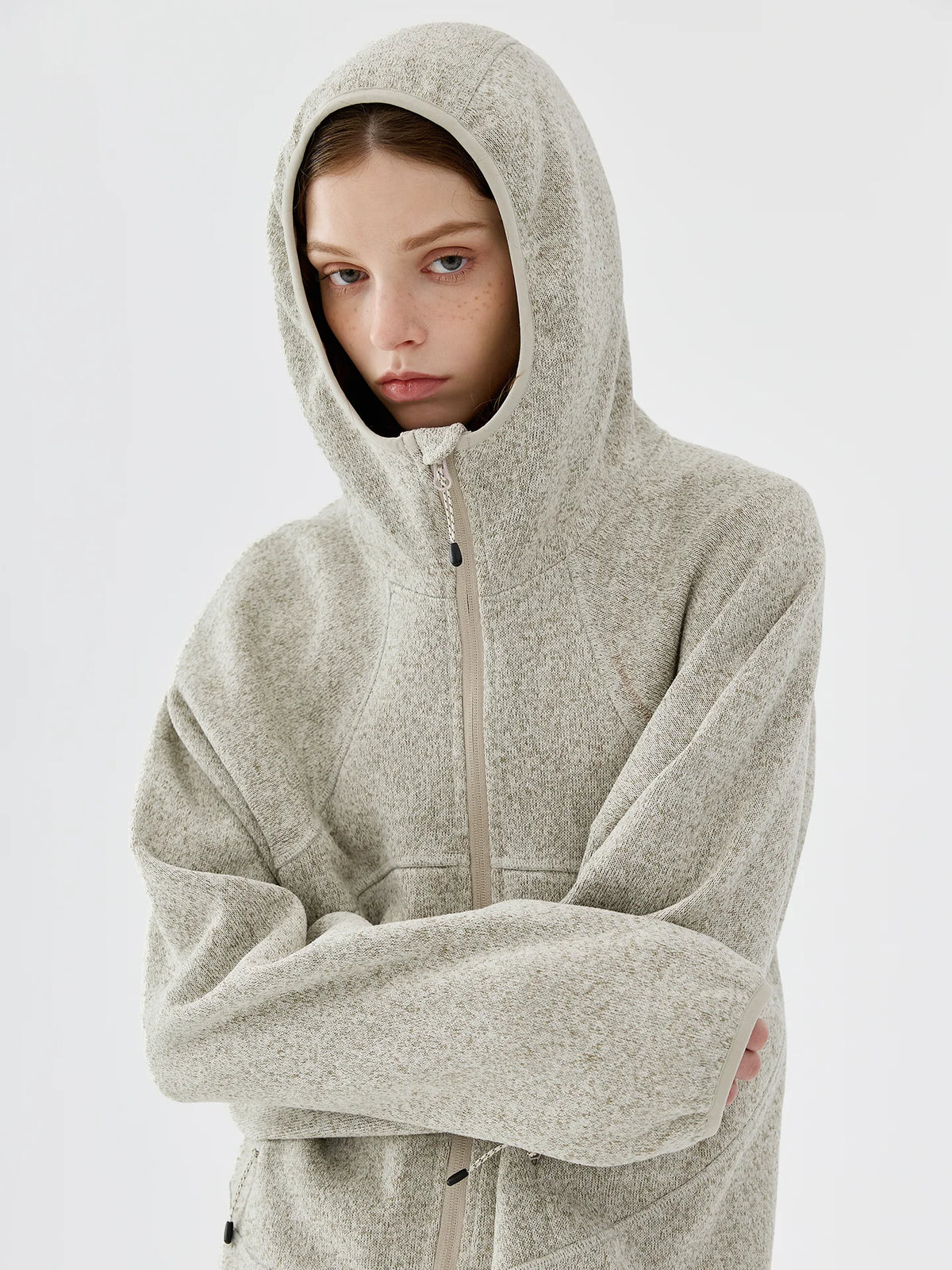 Close-up of model wearing the hood of a light grey melange knit fleece jacket